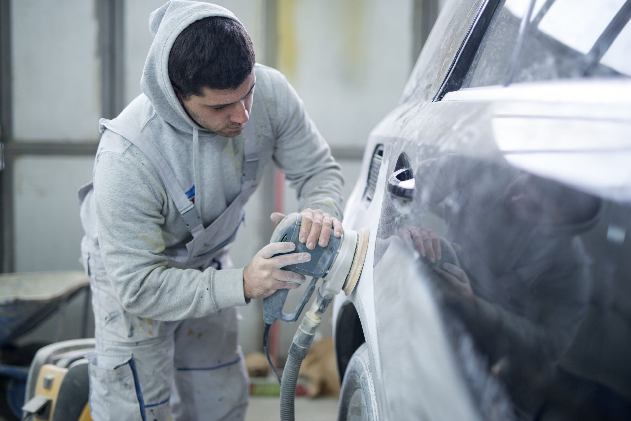 Shot of professional repairman preparing vehicle for new paint.